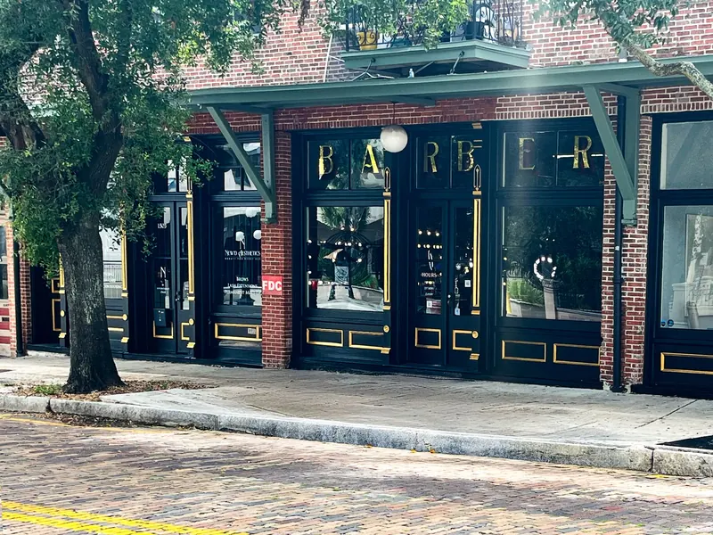 A brick storefront with large black-framed windows and the word 